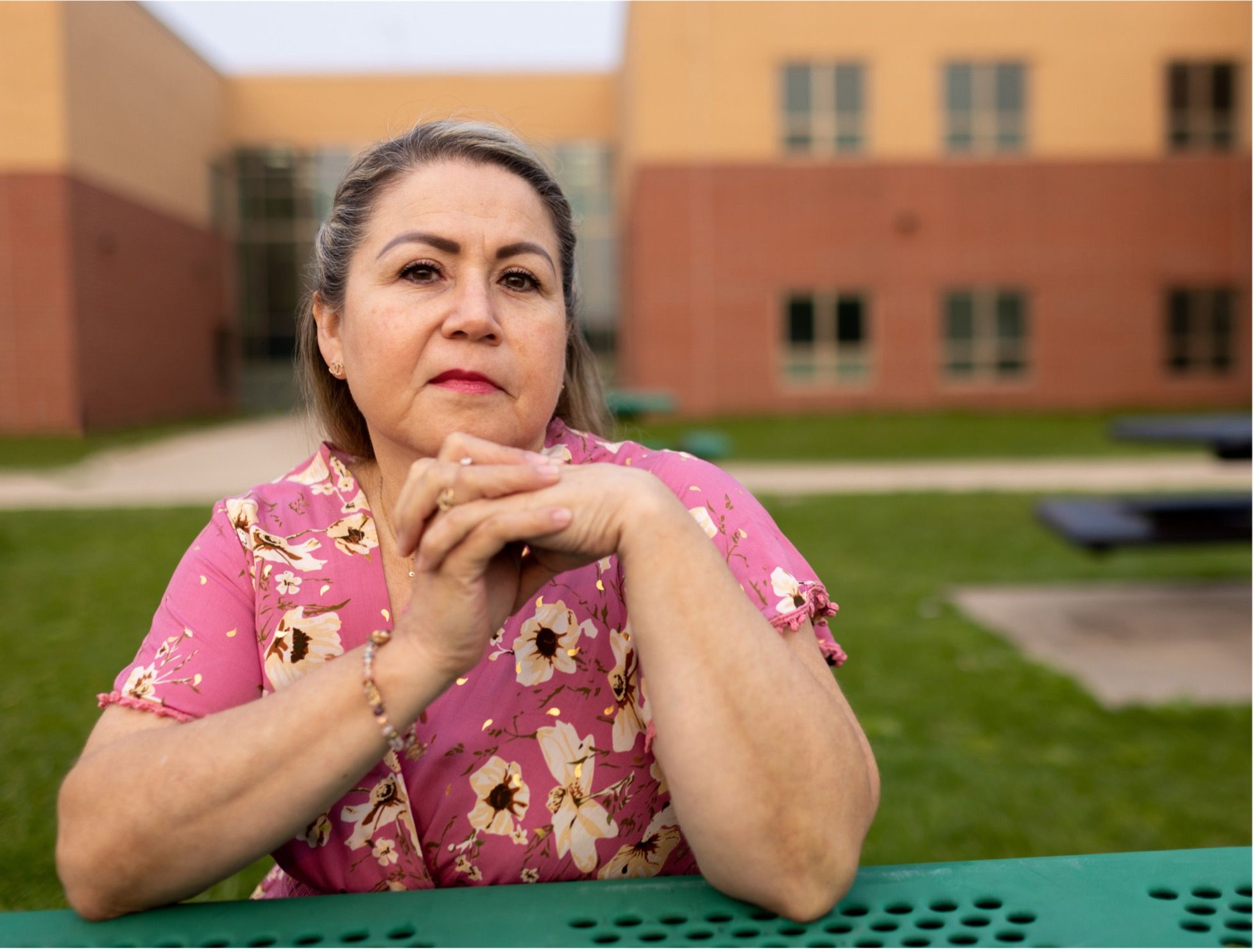 Zulma Zoraida Limas Rodriguez sitting outside, looking at the camera unsmiling with her chin in her hands | Photo by Sharon Vanorny